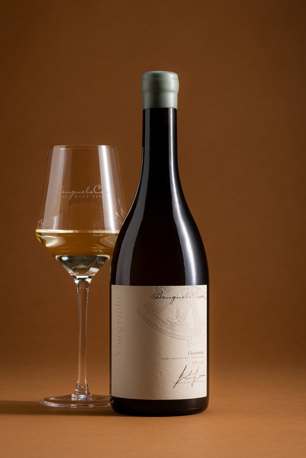 Wine bottle with a glass of wine on a brown background
